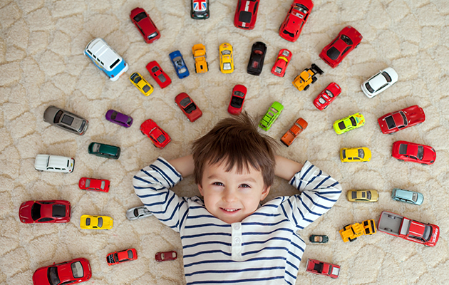 niño con coloridos coches de juguete
